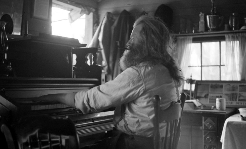 Charlie Coffin, the Hermit of Maine, playing his piano.