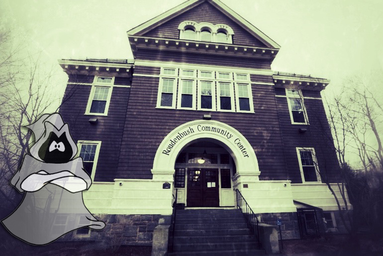 The haunted Roudenbush Community Center building in Westford, Massachusetts, shadowed by the modern school's Grey Ghost mascot.