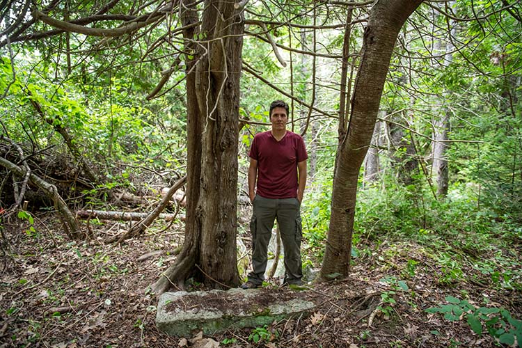 Jeff Belanger standing at the steps that lead down into the former Blaisdell Cellar Hole where the ghost of Nelly Butler appeared back in 1800. Photo by Frank Grace.