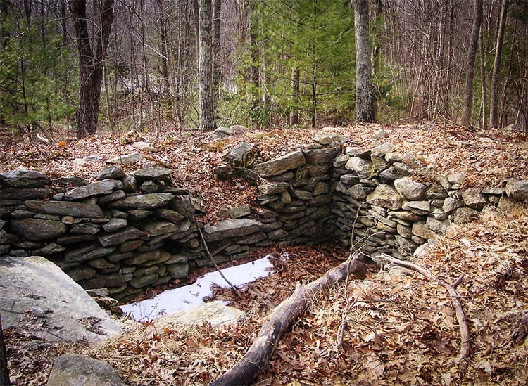 A cellar hole in the ruins of Hanton City ghost town.